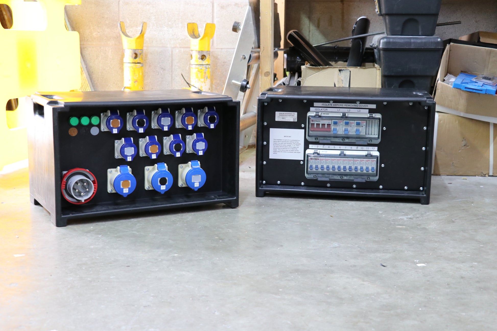 TWO DISTRO BOXES ON WORKSHOP FLOOR, COLOUR CODED SOCKETS AND BREAKERS